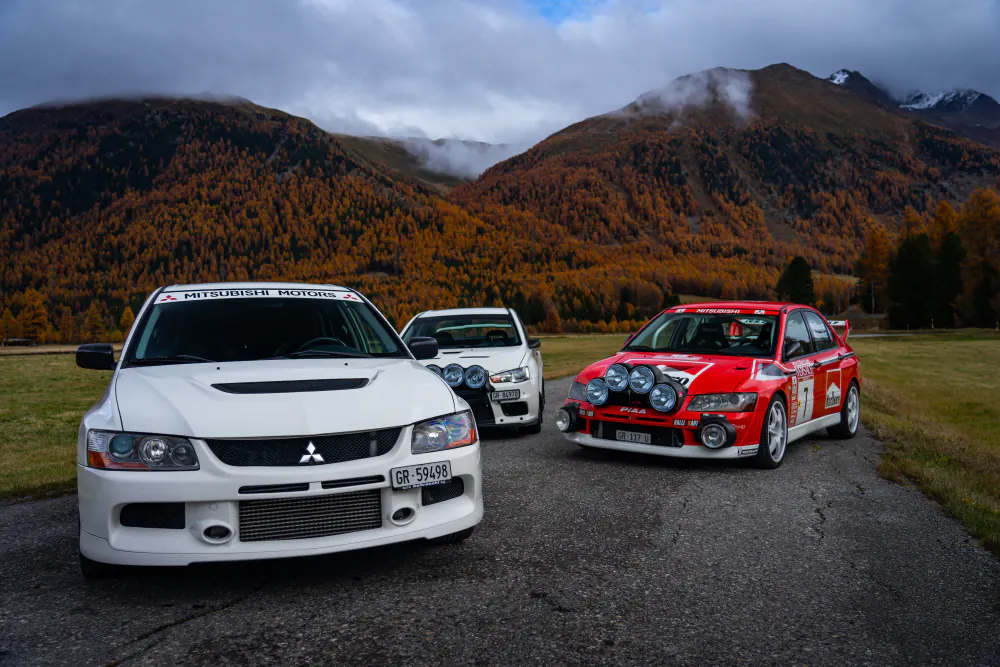 Mitsubishi Evos vor gelben Lärchenwäldern im Engadiner Herbst