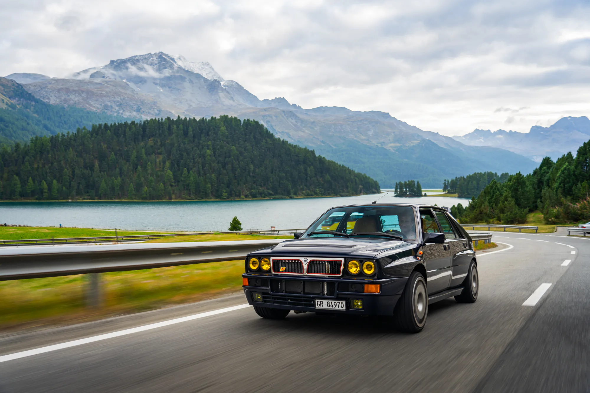 Schwarzer Lancia Delta auf der Seestrasse vor den Engadiner Bergen